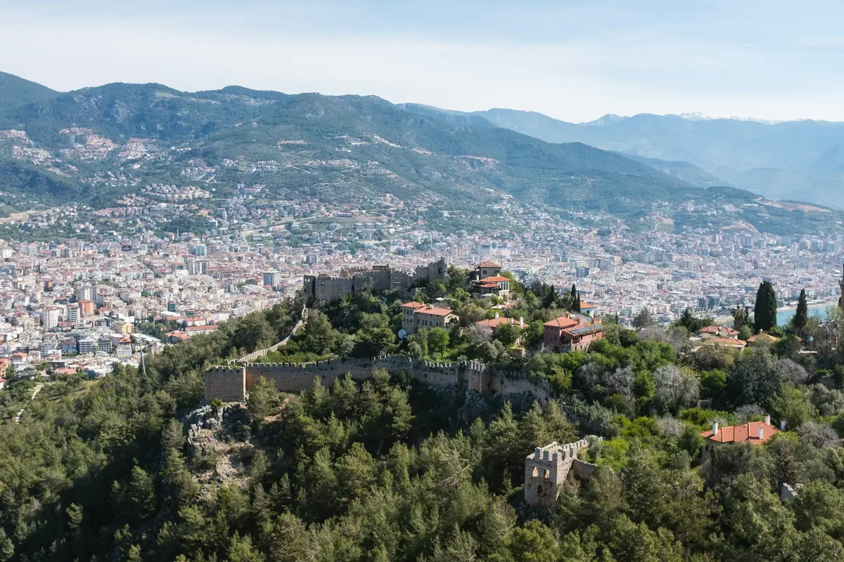 The walls of Alanya castle on the hill with the town behind